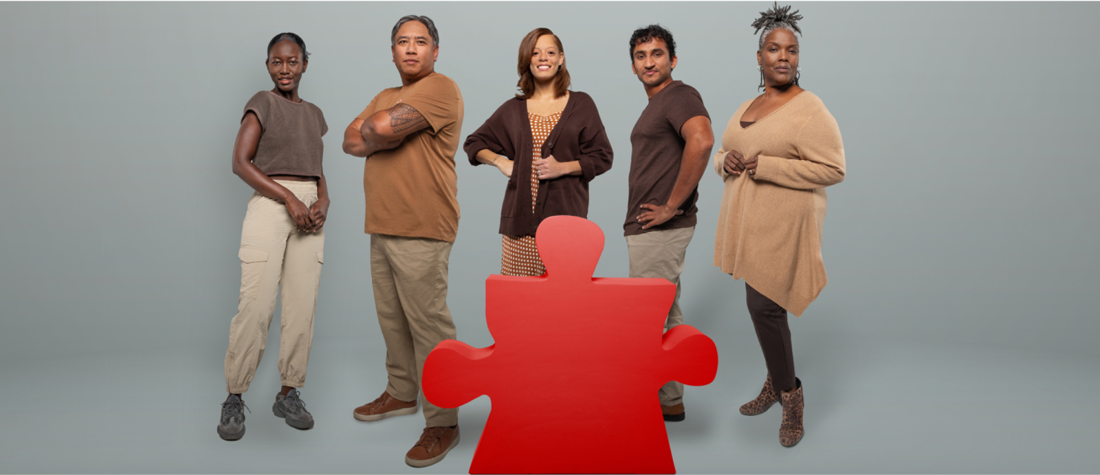 Five people of color standing with one missing puzzle piece shape in the middle