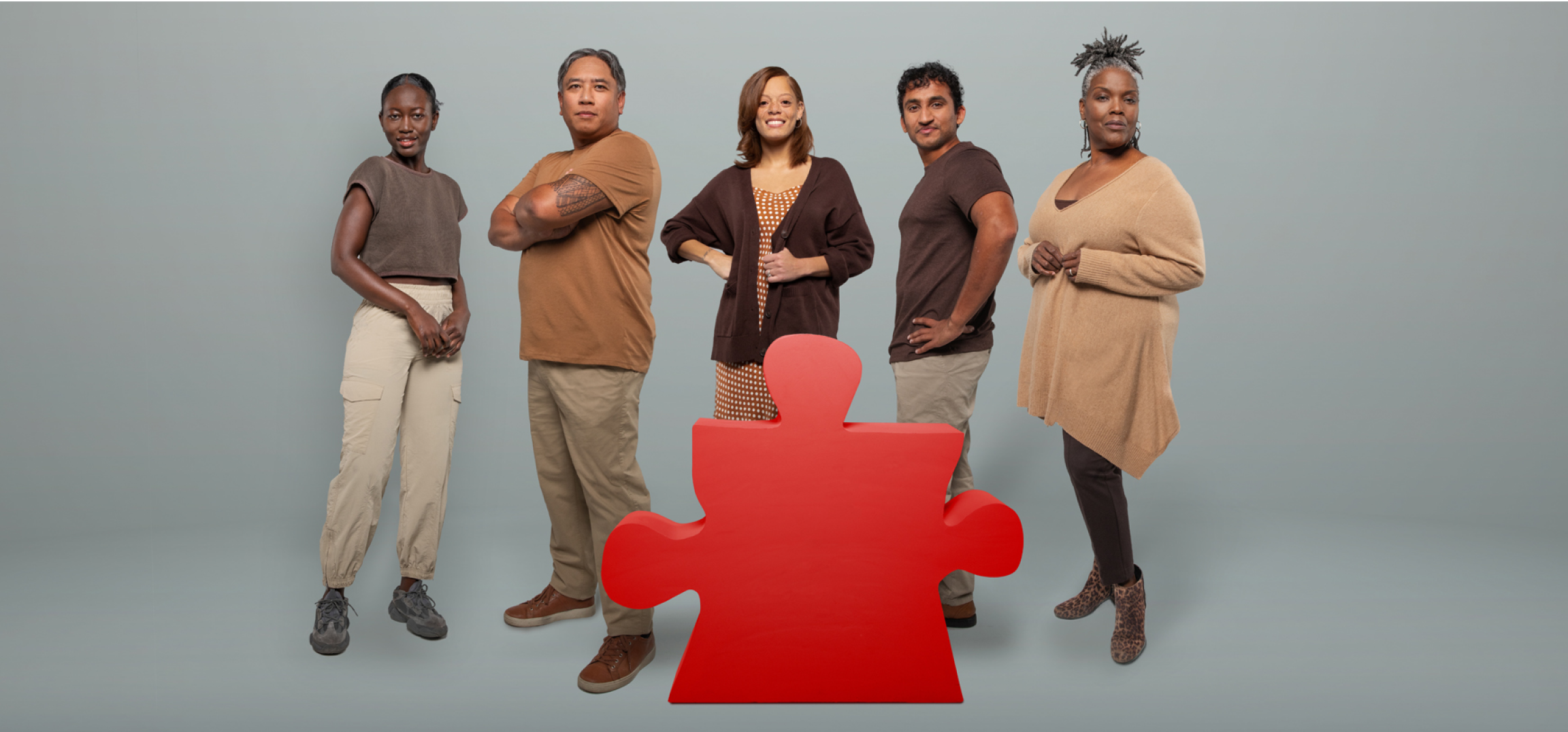 Five people of color standing with one missing puzzle piece shape in the middle
