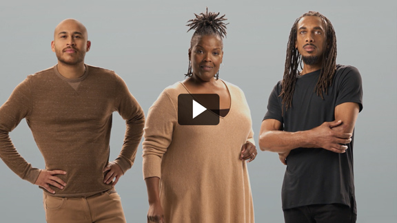 Three people of color standing and looking into camera